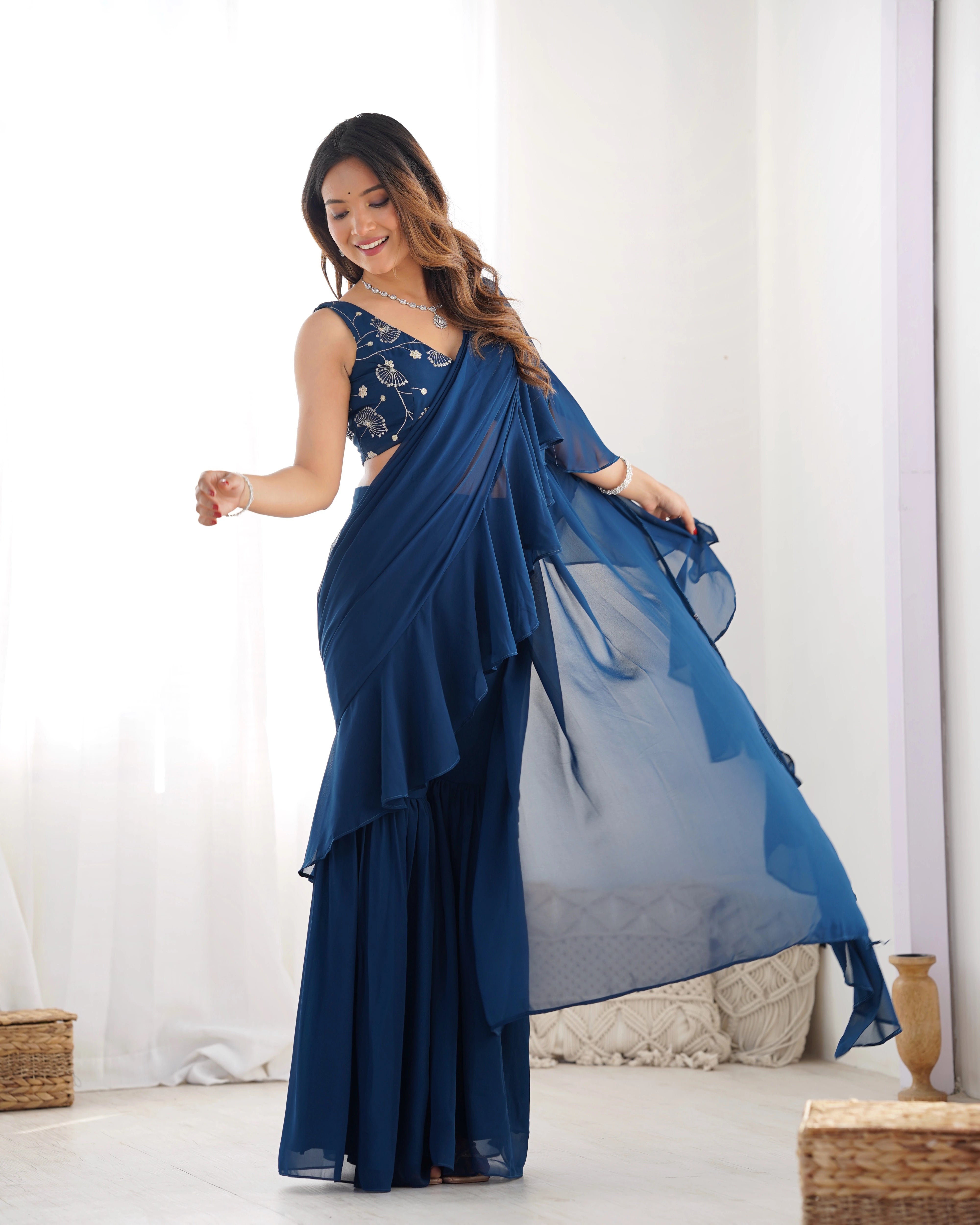 Woman wearing a blue saree with a white background